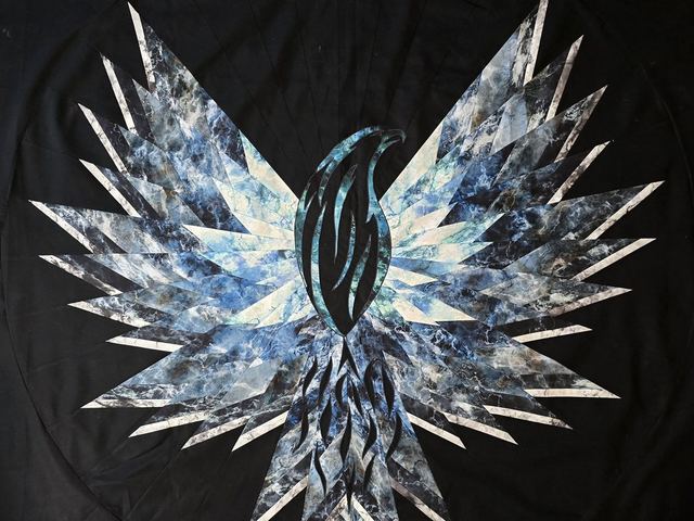 A quilt of outstretched wings in blues and white against black