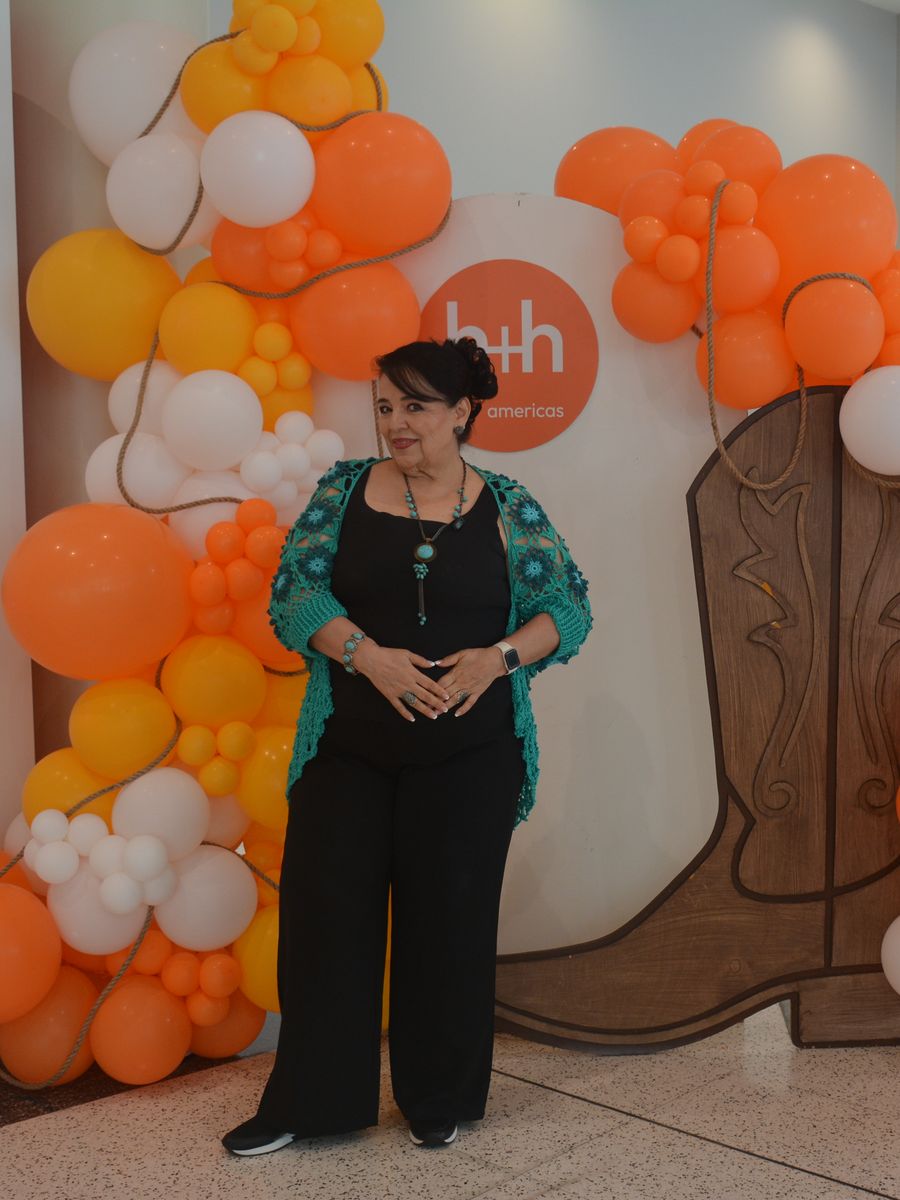 Attendee at the h+h americas Fall Edition balloon arch with the Houston boots