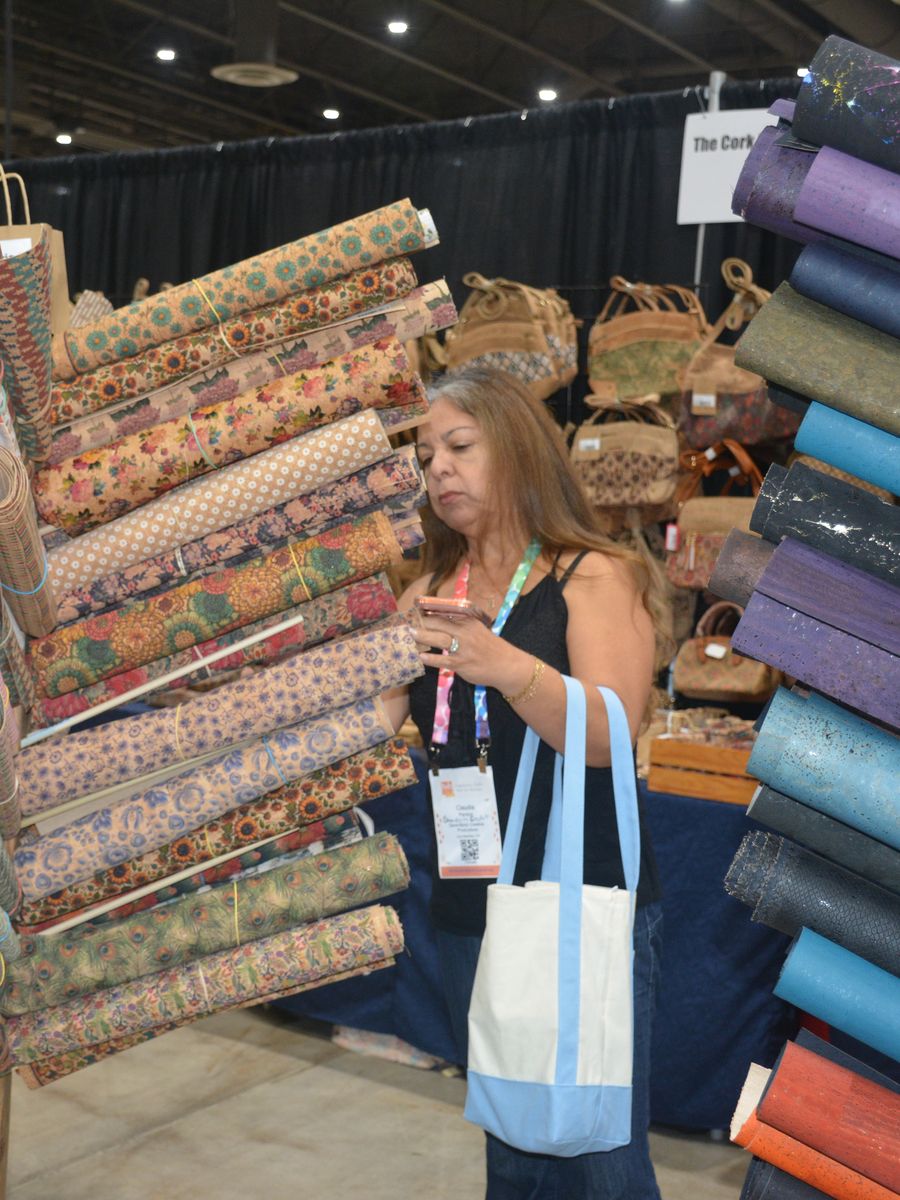 Buyer browsing bolts of fabric on an exhibitor stand