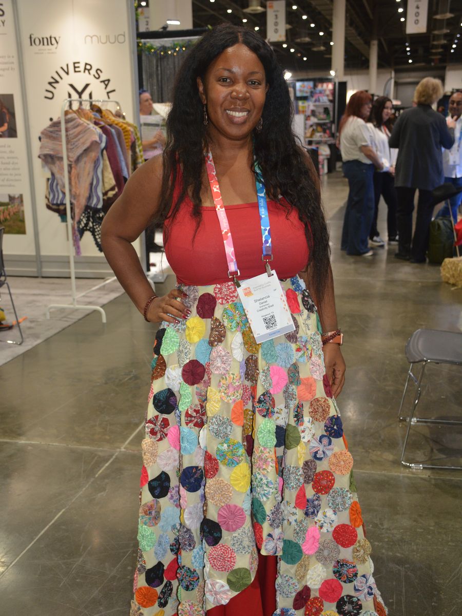 Exhibitor wearing a hand-crocheted garment on the show floor