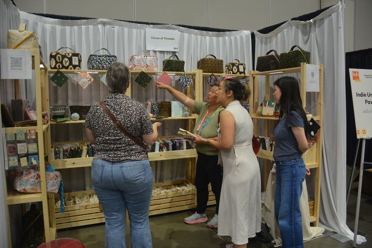 Buyers browsing handbags on an exhibitor stand