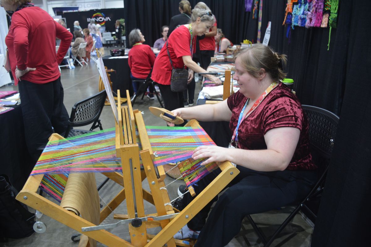 An exhibitor demonstrating a weaving loom at the Fall 2026 show
