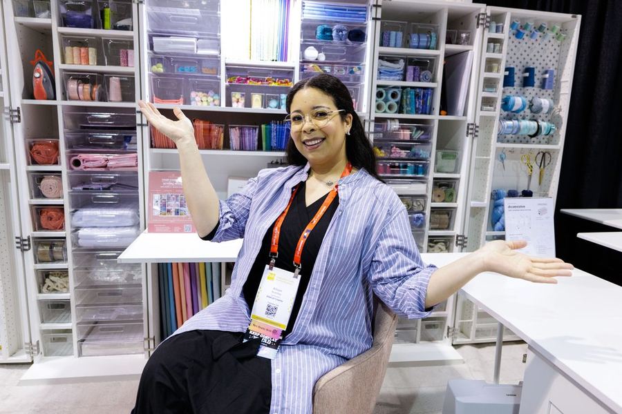 An exhibitor showing needlework tools and storage