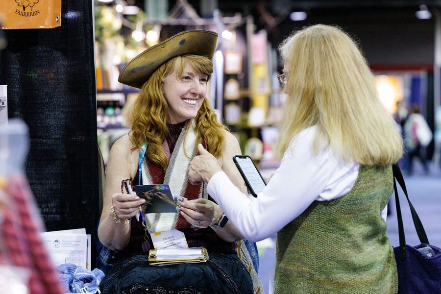 A seller managing orders on her phone at the show