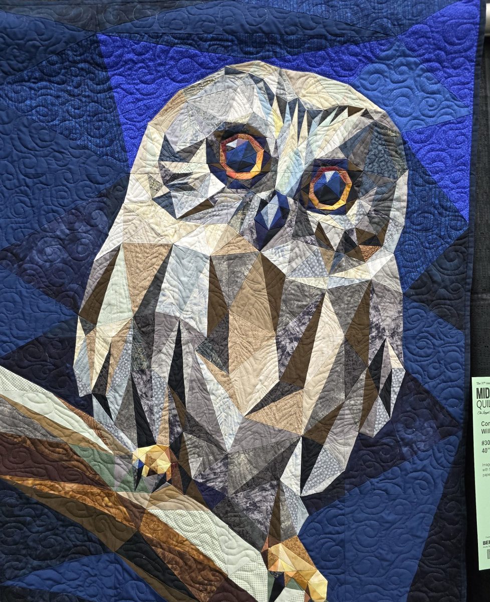 A foundation paper-pieced owl quilt by Legit Kits, built from angular fabric facets in greys and browns against a deep blue background