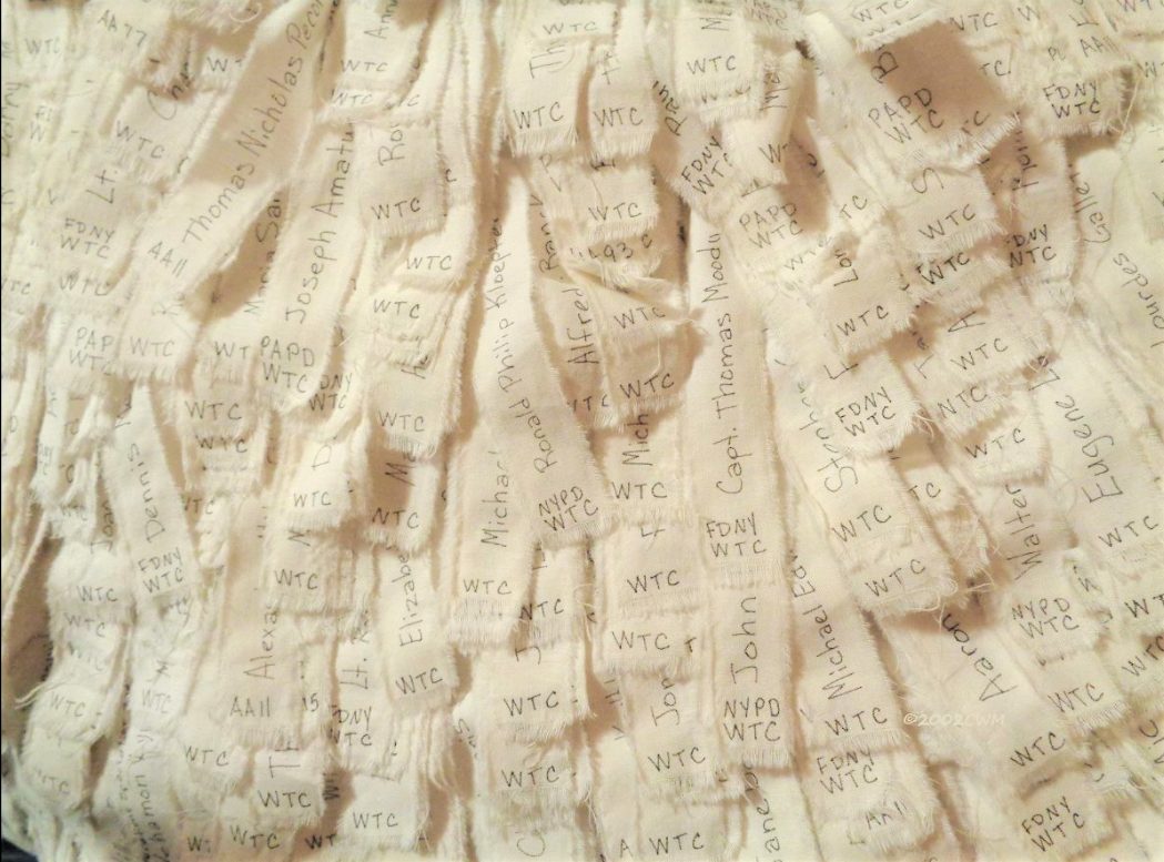 Detail of the quilt Remember Me: rows of hand-lettered fabric strips, each carrying the name of a person lost on September 11, 2001